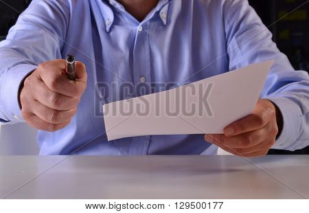 It is time to sign the document.Giving the document to sign.Business man holding a document to sign.