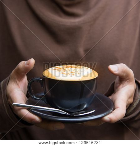 Man holding hot cappuccino coffee cup as baverage background