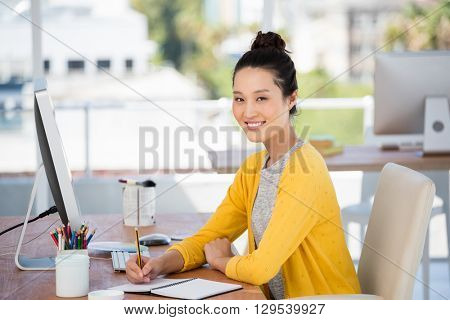 A woman is working at her deskin her office