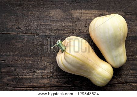 Flat lay two butternut squash on wooden table copyspace