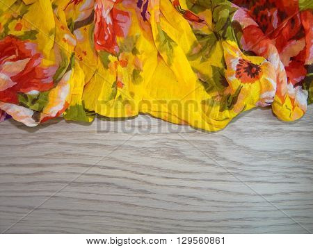 multi-colored fabric with drawings laid in the crease on the wooden planks
