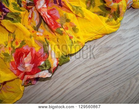 multi-colored fabric with drawings laid in the crease on the wooden planks