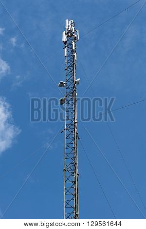 Cell phone tower, blue sky with clouds