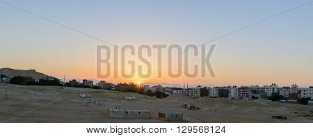 city on the edge of the desert during the evening twilight