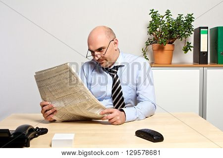 Manager Studies The Financial Part Of A Newspaper.