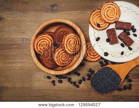 There are Pieces of Roll with Poppyseed,Cookies,Halavah Chocolate Peas,Tasty Sweet  Food on the Wooden Background,Toned