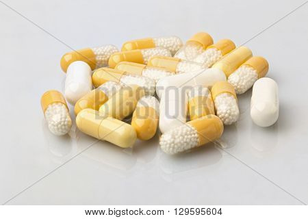 Various medical dosage capsule white and yellow. Close-up on white background