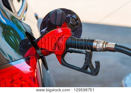 Close up of red fuel nozzle fill enegry of the car.