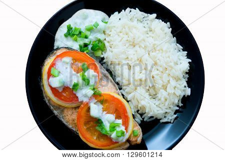 Steak of Keta cooked with tomato, rice, onion and lemon . Delicious dish of keta