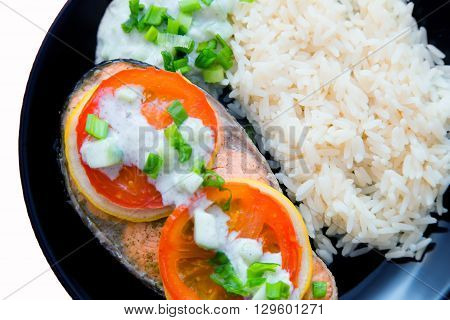 Steak of Keta cooked with tomato, rice, onion and lemon . Delicious dish of keta