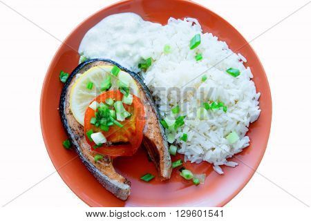 Steak of Keta cooked with tomato, rice, onion and lemon . Delicious dish of keta