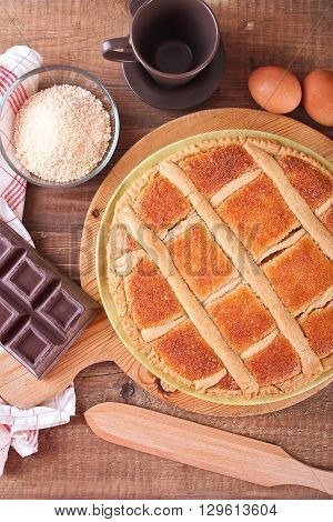 Image of chocolate coconut tart on wooden breadboard.
