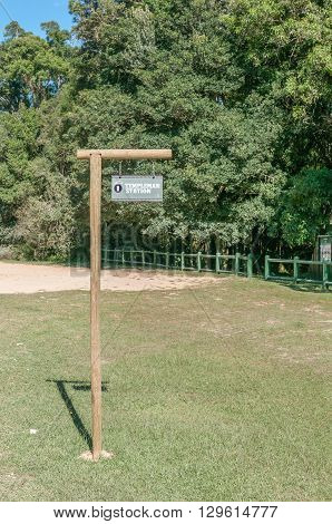 KNYSNA SOUTH AFRICA - MARCH 5 2016: Signpost where the historic Templeman Station stood at the Ysterhoutrug picnic spot in the Knysna Forest. The railway ceased operation in 1949