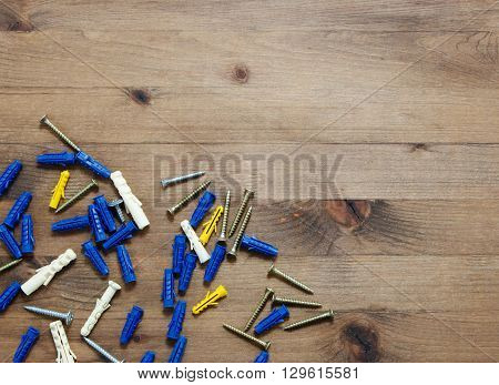 screws with blue and yellow dowels on wooden table