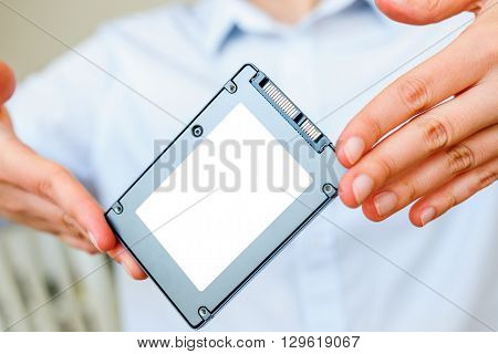 Hands holding fast flash SSD - solid state drive with sata 6 gb connection - blacnk place for diverse informateion and text to be inserted