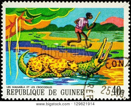 MOSCOW RUSSIA - MAY 12 2016: A stamp printed in Guinea shows leopard on a crocodile and a black hunter series 
