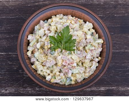 Russian traditional salad olivier with pea in the plate. Close up