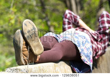 Macro photo of shoe soles. Girl resting on nature after a long physical activity