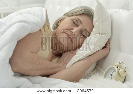Sleeping senior woman portrait in a bed