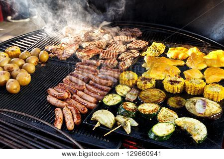 Large Hot Barbecue With Meat, Sausages And Vegetables Being Cooked.