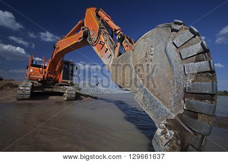 Construction excavator mechanical arm getting ready to scoop earth