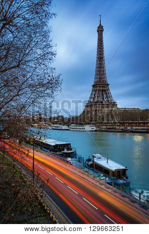Eiffel Tower at twilight on cloudy winter morning with the Seine River and car light trails. Paris, Grenelle, 7th Arrondissement, France