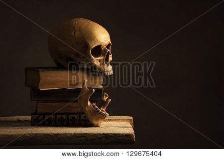 Human Skull with Jawbone on old Book