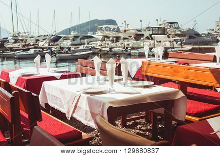 View of empty outdoor cafe near lagoon with yachts