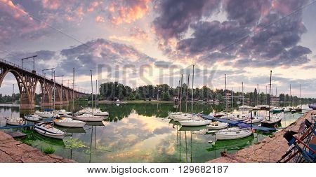 Sunrise on the river with yachts in purple colors. Central embankment  Dnepropetrovsk city, Ukraine in summertime.