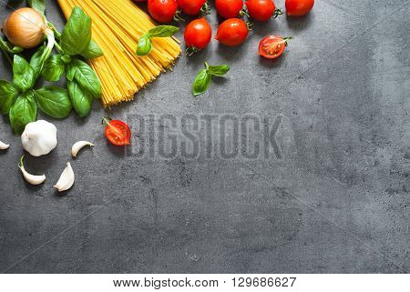 Ingredients for cooking Italian pasta - spaghetti tomatoes basil and garlic. Top view with space for taxt.