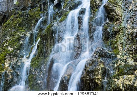 Waterfall at talc quarry among the mossy stones