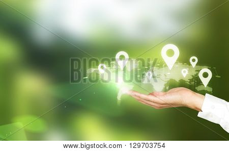 Map with location pins in businessman's hand on green background. Traveling concept