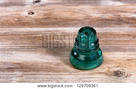 Antique electric glass insulator on rustic wood.
