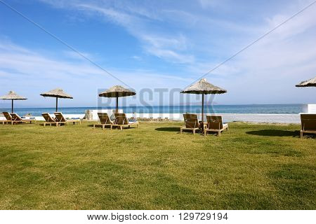The ambrellas blue sea and sky on the cretan beach in Greece.