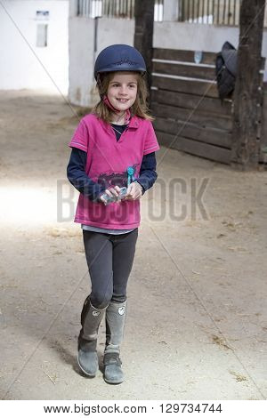 pretty young teenage girl preparing taking care horse poney