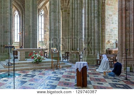 Mont St. Michel France - May 22 2012: Normandy a nun in prayer in the church of the abbey