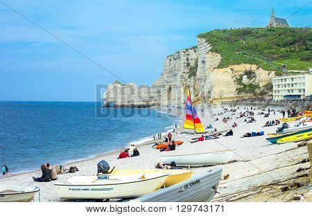 Etretat France - May 19 2012: Normandy local people relaxing on the beach near the cliffs .