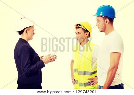 Female engineer talking with two builders