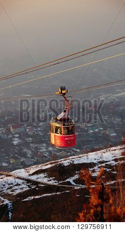ALMATY, KAZAKHSTAN - January 20, 2016: funicular with tourists and view of the foggy city of Almaty, Kazakhstan
