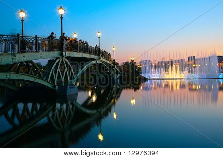 gente en el puente y fuente en puesta de sol. Moscú.