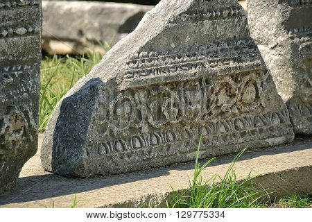 A fragment of an ancient stone frieze on the excavation. Greece. Photo