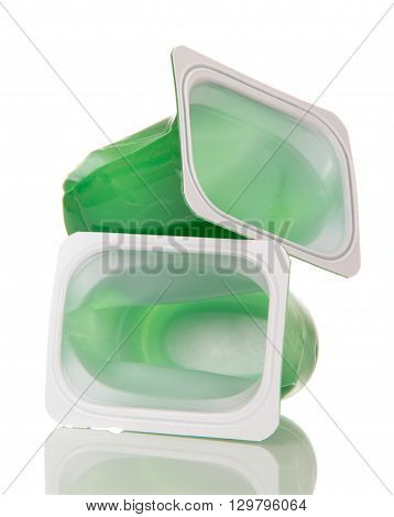 Crushed plastic cups of yogurt isolated on white background.