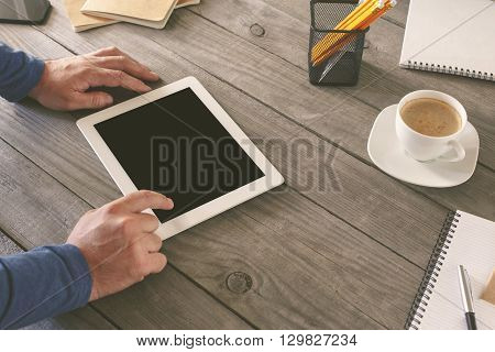 Man working in a home office. Men hand clicks on the tablet screen on wooden table. concept man working from home using tablet computer or working outside the office