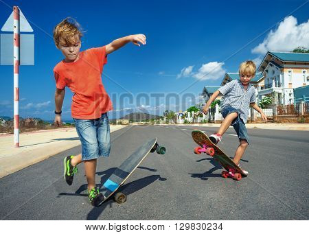Little boys on longboard skate 