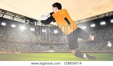 soccer or football goalkeeper is catching ball on stadium