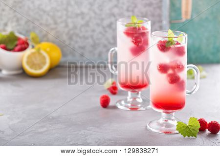 Pink refreshing cold raspberry lemonade in tall glasses