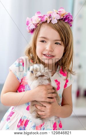 Beautiful little girl four years old holding white rabbit