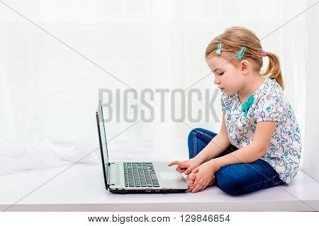 Four years old girl working on laptop
