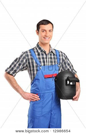 Un lavoratore indossa un complessivo e tenendo una maschera di saldatura