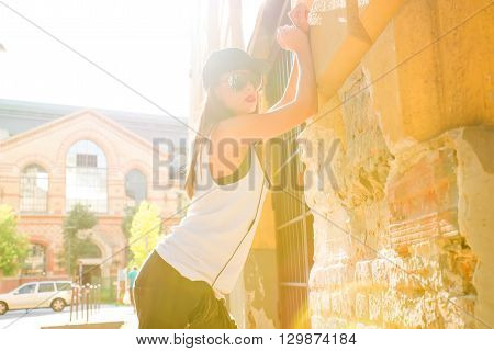 A beautiful young Hip Hop Rapper girl with Headphones in a urban environment.